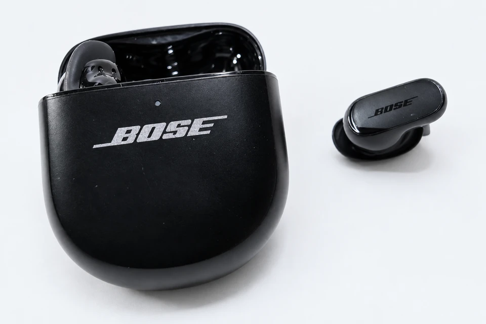 Black Bose QuietComfort Ultra Earbuds (2nd Gen), with one earbud beside the open charging case